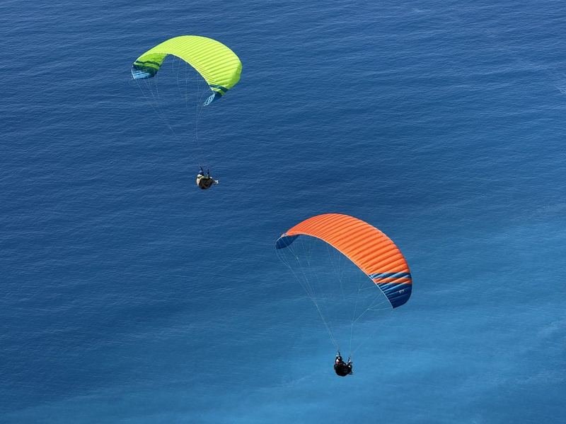 Two paragliders flying over the sea