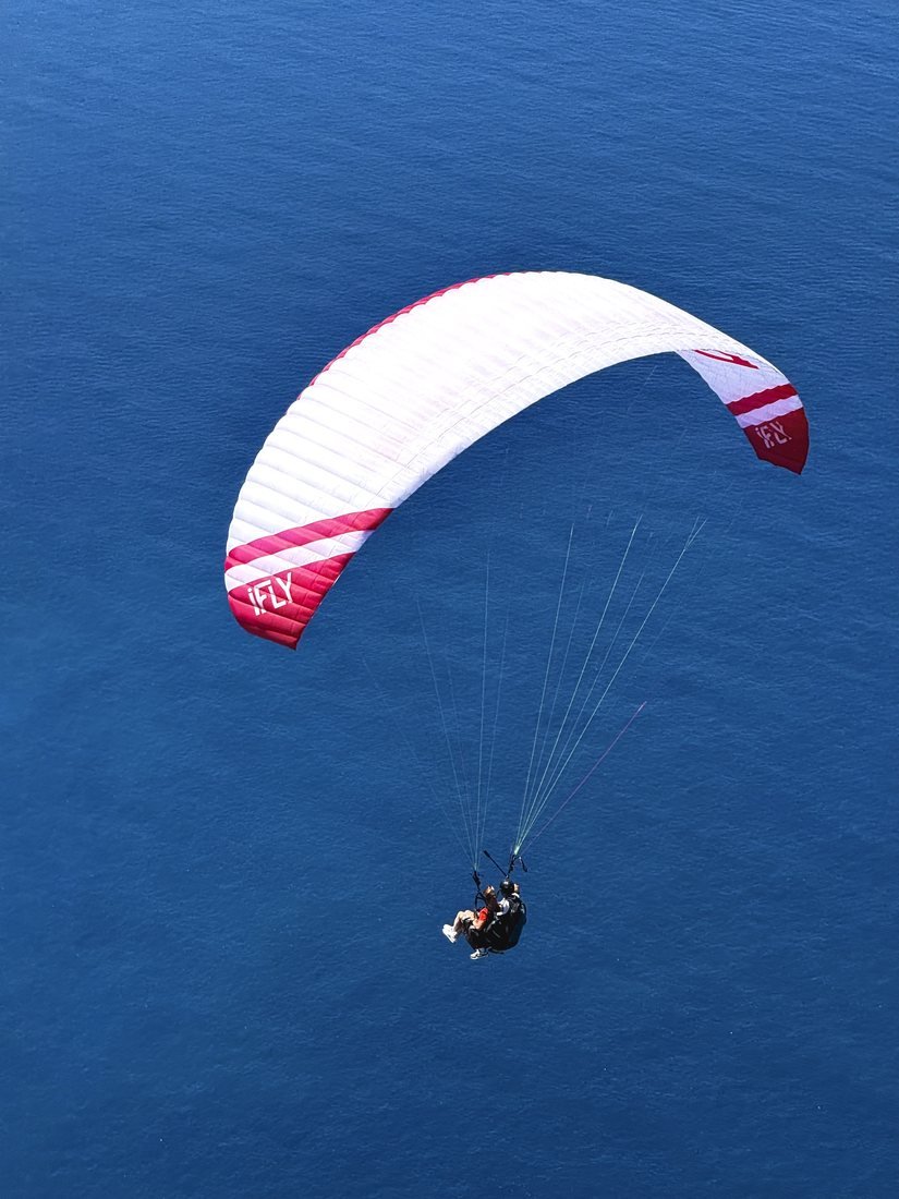 A pilot flying a single wing over the sea